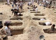 <p>Yemenis dig graves for children, who where killed when their bus was hit during a Saudi-led coalition air strike, that targeted the Dahyan market the previous day in the Huthi rebels’ stronghold province of Saada on Aug. 10, 2018. (Photo: Stringer/AFP/Getty Images) </p>