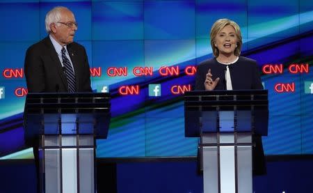 Democratic presidential candidate U.S. Senator Bernie Sanders listens as former Secretary of State Hillary Clinton speaks during the first official Democratic candidates debate of the 2016 presidential campaign in Las Vegas, Nevada October 13, 2015. REUTERS/Lucy Nicholson