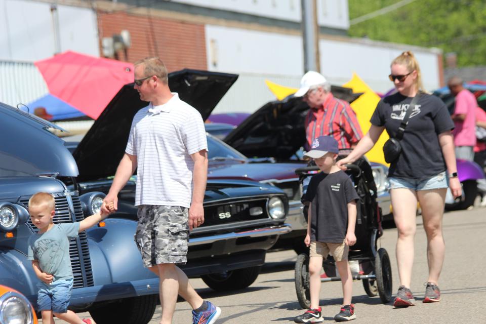 A family checks out cars entered in the annual Cruise In Saturday during Riverfest in Jonesville.