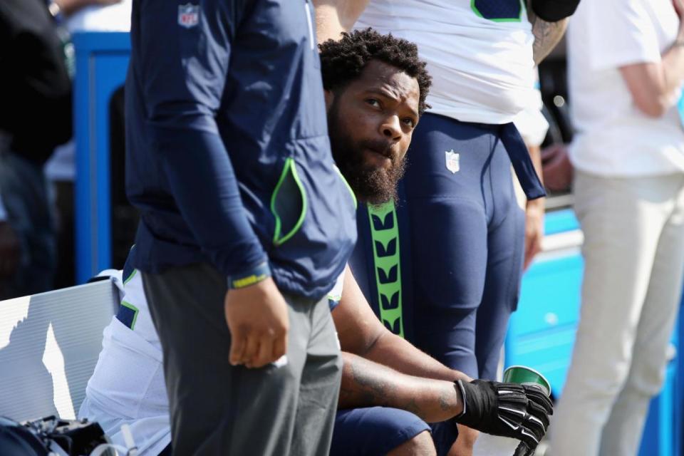 NFL player Michael Bennett of the Seattle Seahawks sits on the bench during the national anthem (Getty Images)