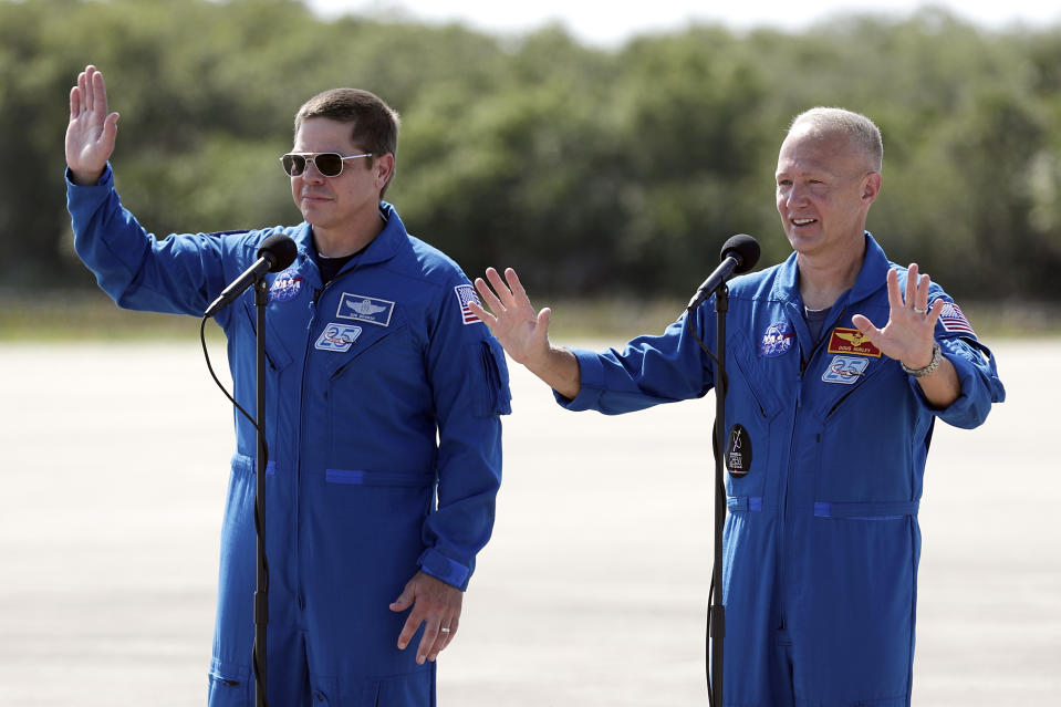 NASA astronauts Bob Behnken, left, and Doug Hurley wave as they leave a news conference after they arrived at the Kennedy Space Center in Cape Canaveral, Fla., Wednesday, May 20, 2020. The two astronauts will fly on the SpaceX Demo-2 mission to the International Space Station scheduled for launch on May 27. (AP Photo/John Raoux)