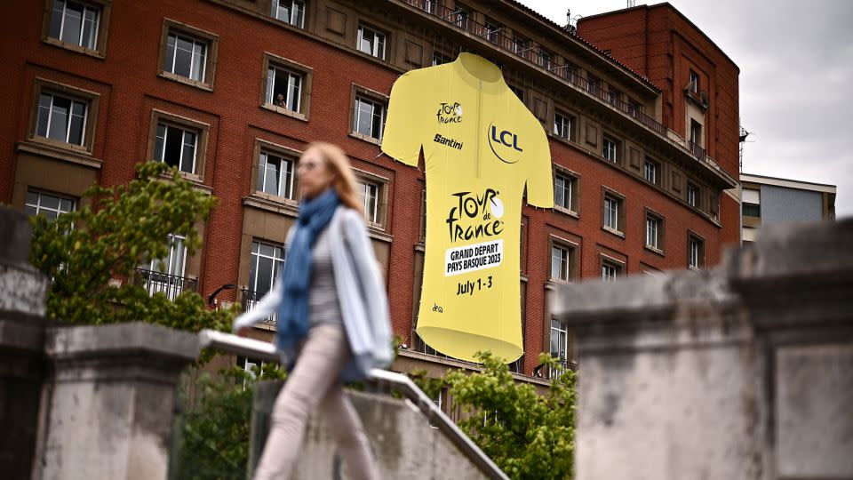 A pedestrian walks past a giant yellow jersey ahead of the 110th edition of the Tour de France in Bilbao. - Marco Bertorello/AFP/Getty Images