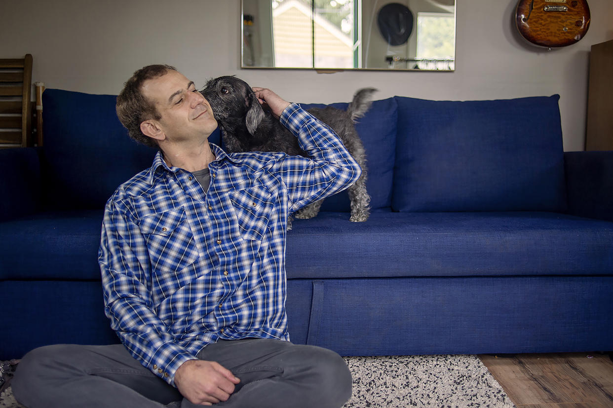 Nigel McCourry, un infante de la Marina retirado que participó en un ensayo clínico en el que se utilizó la droga psicodélica MDMA, combinada con terapia, para tratar su trastorno de estrés postraumático, con su perro Kiko en su casa de Portland, Oregón, el 21 de febrero de 2022. (Amanda Lucier/The New York Times).