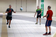 England rugby fans warm up with a rugby ball at an underground pathway in Tokyo Saturday, Oct. 12, 2019. A heavy downpour and strong winds pounded Tokyo and surrounding areas on Saturday as a powerful typhoon forecast as the worst in six decades approached landfall, with streets and train stations deserted and shops shuttered. (AP Photo/Eugene Hoshiko)