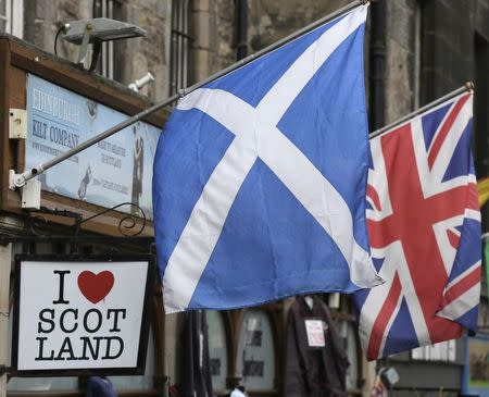 The Scottish Saltire flag (L) and the British Union flag are seen outside a shop in the centre of Edinburgh, Scotland September 12, 2014. REUTERS/Paul Hackett