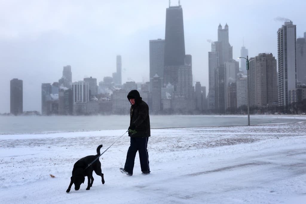 Un homme devant le lac Michigan au lever du soleil alors que les températures oscillaient autour de -8 degrés le 22 décembre 2022 à Chicago. - SCOTT OLSON / GETTY IMAGES NORTH AMERICA / Getty Images via AFP