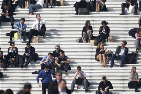 Businessmen enjoy the good weather at lunch time on the steps of the Arche de la Defense, in the financial and business district west of Paris, as warm and sunny weather continues in France, March 13, 2014. REUTERS/Charles Platiau