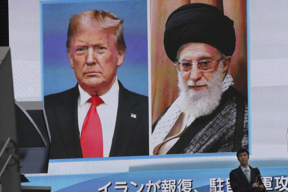 A man walks by a huge screen showing U.S. President Donald Trump, left, and Iranian Supreme Leader Ayatollah Ali Khamenei, in Tokyo, Wednesday, Jan. 8, 2020. Iran struck back at the United States early Wednesday for killing a top Revolutionary Guards commander, firing a series of ballistic missiles at two military bases in Iraq housing American troops in a major escalation between the two longtime foes. (AP Photo/Koji Sasahara)