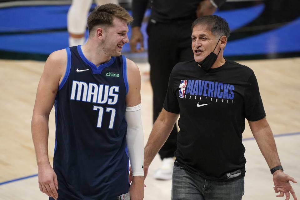 Dallas Mavericks guard Luka Doncic (77) smiles as he talks with team owner Mark Cuban as they walk off the court after the team's win in an NBA basketball game against the Detroit Pistons in Dallas, Wednesday, April 21, 2021. (AP Photo/Tony Gutierrez)