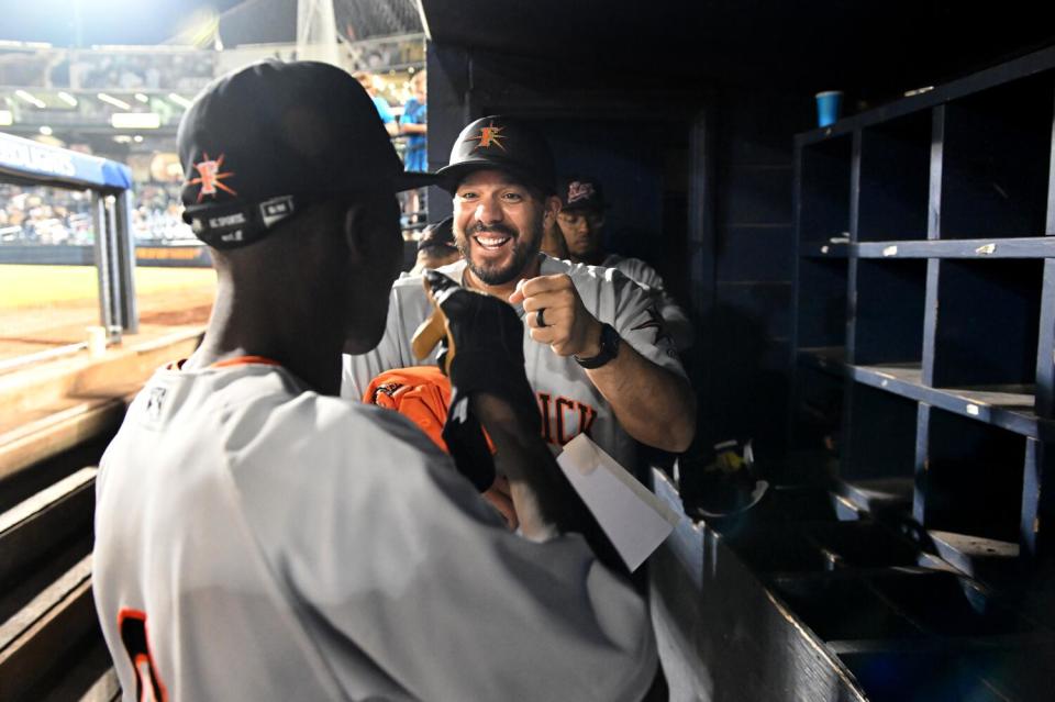 Frederick Keys manager Rene Rivera bumps fists with Dennis Kasumba after his first at-bat during a game in Trenton, N.J.