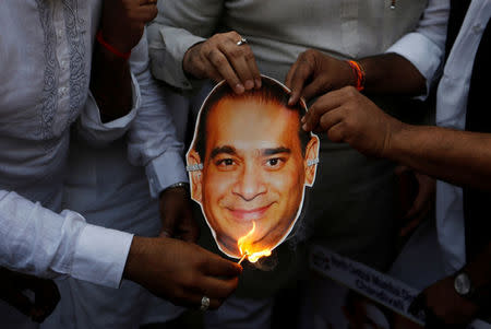 Activists of the youth wing of India's main opposition Congress party burn a cut-out with an image of billionaire jeweller Nirav Modi during a protest inÊMumbai, India, February 23, 2018. REUTERS/Francis Mascarenhas