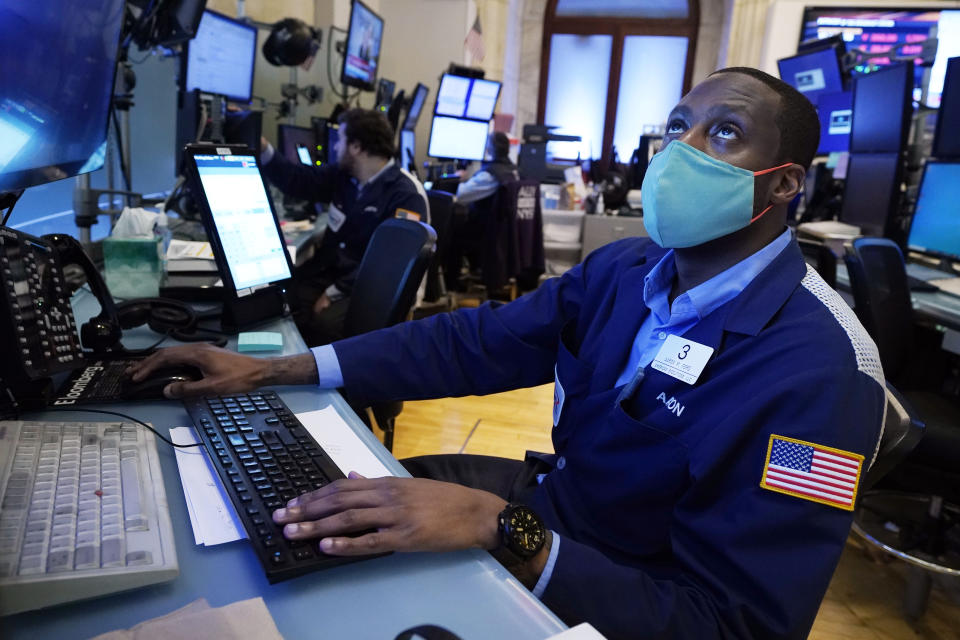 Trader Aaron Ford works on the floor of the New York Stock Exchange, Monday, July 19, 2021. Resurgent pandemic worries knocked stocks lower from Wall Street to Tokyo on Monday, fueled by fears that faster-spreading variants of the virus may upend the economy's strong recovery. (AP Photo/Richard Drew)