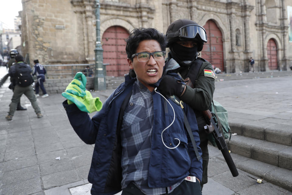 A supporter of former President Evo Morales is detained during clashes with police, in La Paz, Bolivia, Friday, Nov. 15, 2019. Bolivia's new interim president Jeanine Anez faces the challenge of stabilizing the nation and organizing national elections within three months at a time of political disputes that pushed Morales to fly off to self-exile in Mexico after 14 years in power. (AP Photo/Natacha Pisarenko)