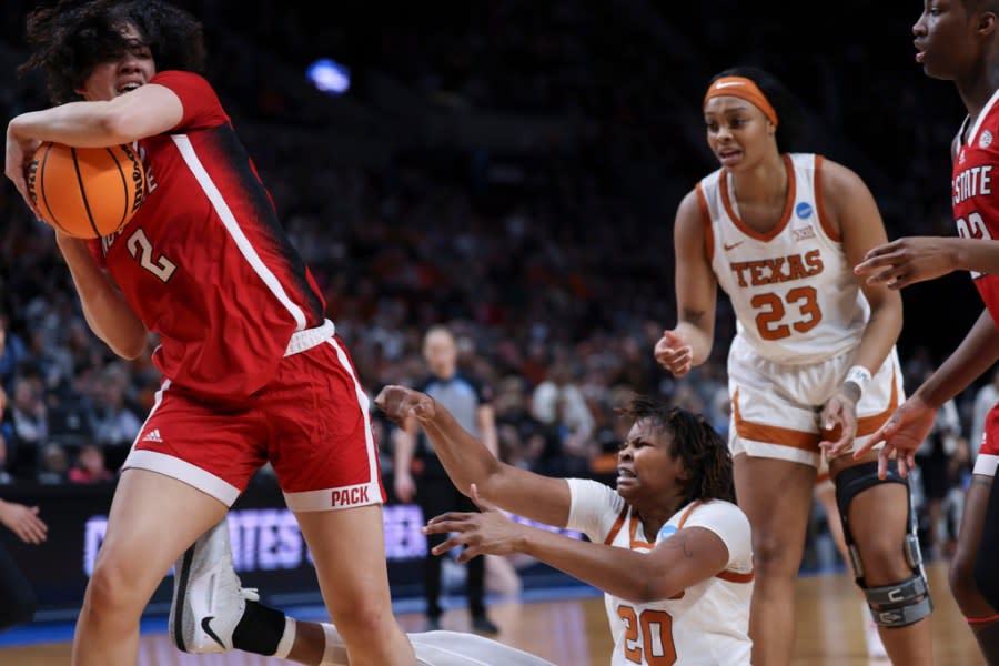 North Carolina State forward Mimi Collins (2) grabs the ball as Texas forward Khadija Faye (20) and forward Aaliyah Moore look on during the first half of an Elite Eight college basketball game in the women’s NCAA Tournament, Sunday, March 31, 2024, in Portland, Ore. (AP Photo/Howard Lao)