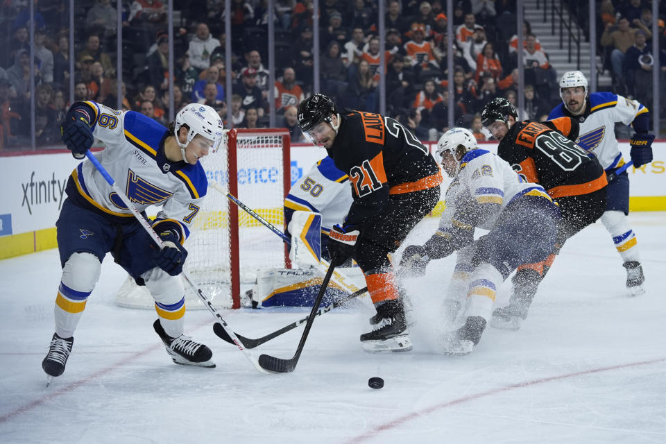 St. Louis Blues' Zack Bolduc, left, and Philadelphia Flyers' Scott Laughton battle for the puck during the second period of an NHL hockey game, Monday, March 4, 2024, in Philadelphia. (AP Photo/Matt Rourke)