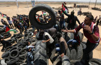 <p>Palestinians collect tires to be burnt during a protest marking the 70th anniversary of Nakba, at the Israel-Gaza border in the southern Gaza Strip, May 15, 2018. (Photo: Ibraheem Abu Mustafa/Reuters) </p>