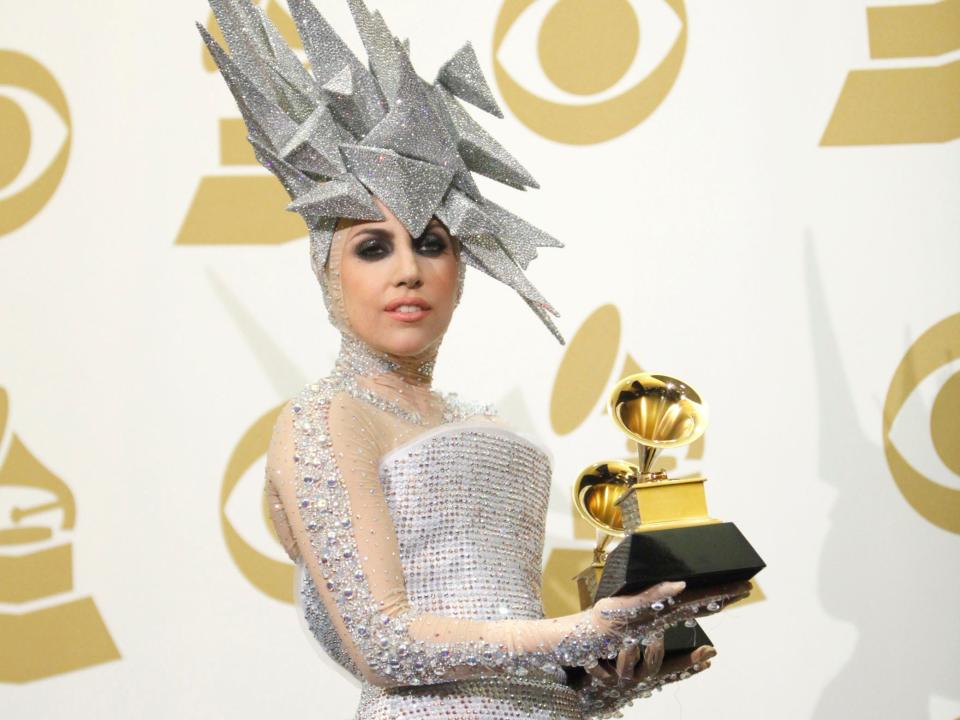 lady gaga holding two grammys at the 2010 grammy awards