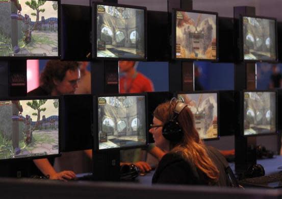 Visitors play 'World of Warcraft' at an exhibition stand during the Gamescom 2012 fair in Cologne August 15, 2012.