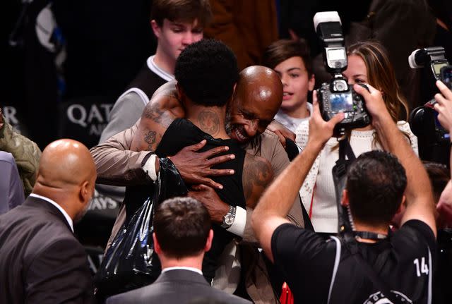 <p>James Devaney/Getty</p> Kyrie IRving hugging his dad Drederick after a game in 2019.