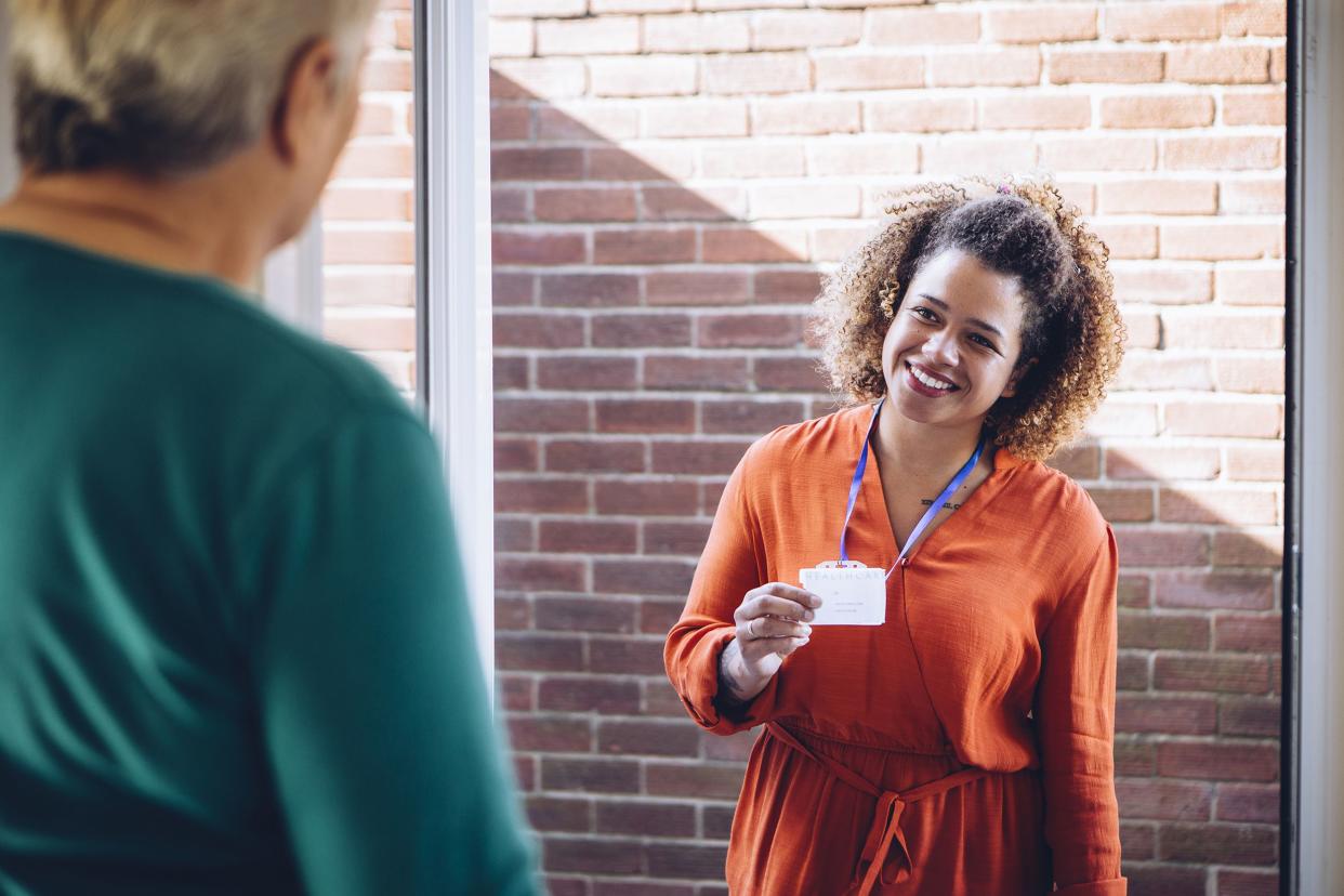 social worker at door of client, showing her name-tag