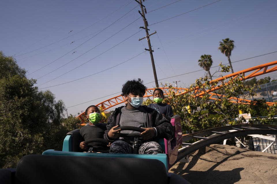 Young visitors ride a roller coaster at Adventure City amusement park on the day of reopening in Anaheim, Calif., Friday, April 16, 2021. The family-run amusement park that had been shut since March last year because of the coronavirus pandemic reopened on April 16. (AP Photo/Jae C. Hong)