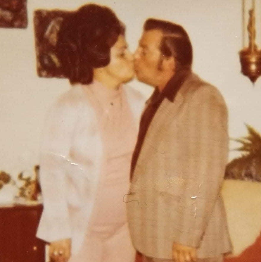 Helen and Paul Mozzochi kissing, as usual, in a family photo.