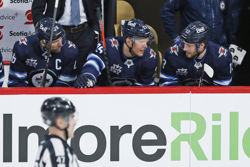 FILE - In this March 31, 2021, file photo, Winnipeg Jets' Blake Wheeler (26), Paul Stastny (25) and Pierre-Luc Dubois (13) talk between shifts during the first period of an NHL hockey game against the Toronto Maple Leafs in Winnipeg, Manitoba. Dubois is looking forward to finally getting to know his Jets teammates after spending much of last season in Winnipeg isolated from them due to COVID-19 protocols coupled with a rash of injuries. (John Woods/The Canadian Press via AP, File)