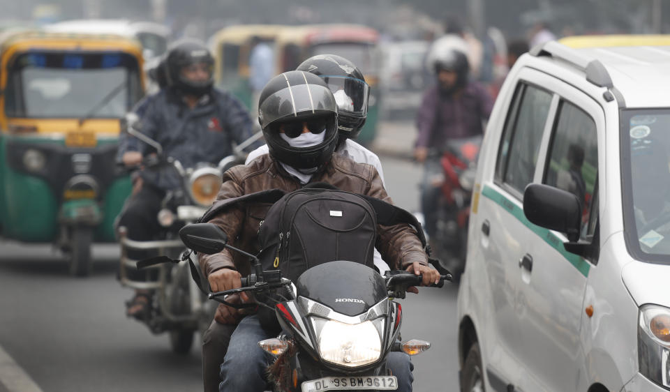 A motorcyclist drives past wearing pollution mask in New Delhi, India, Thursday, Nov. 14, 2019. Schools in India's capital have been shut for Thursday and Friday after air quality plunged to a severe category for the third consecutive day, enveloping New Delhi in a thick gray haze of noxious air. (AP Photo/Manish Swarup)