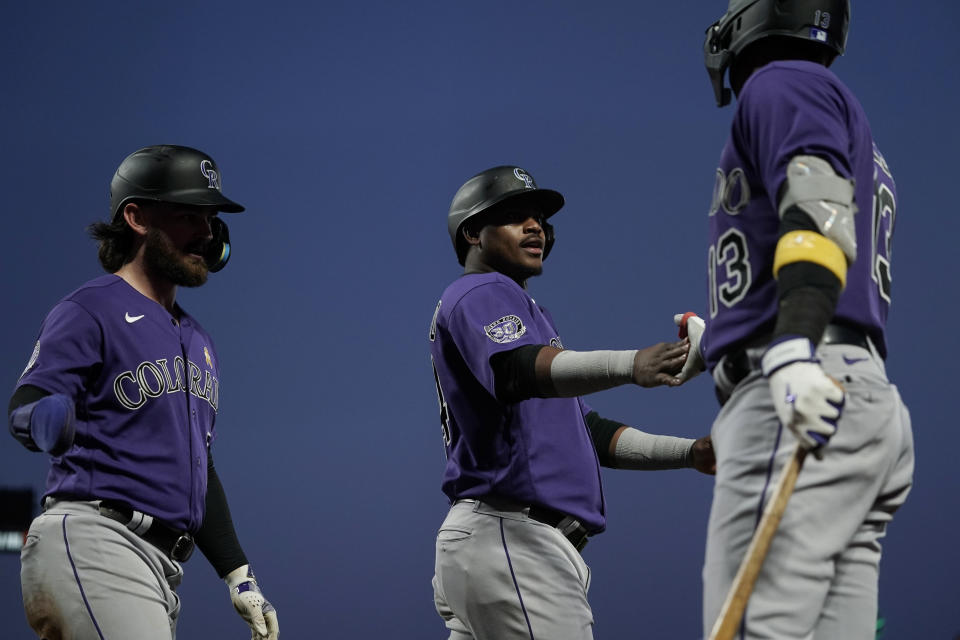 Colorado Rockies' Elehuris Montero, center, celebrates with Alan Trejo, right, after scoring against the San Francisco Giants on Hunter Goodman's triple during the second inning of a baseball game Friday, Sept. 8, 2023, in San Francisco. (AP Photo/Godofredo A. Vásquez)