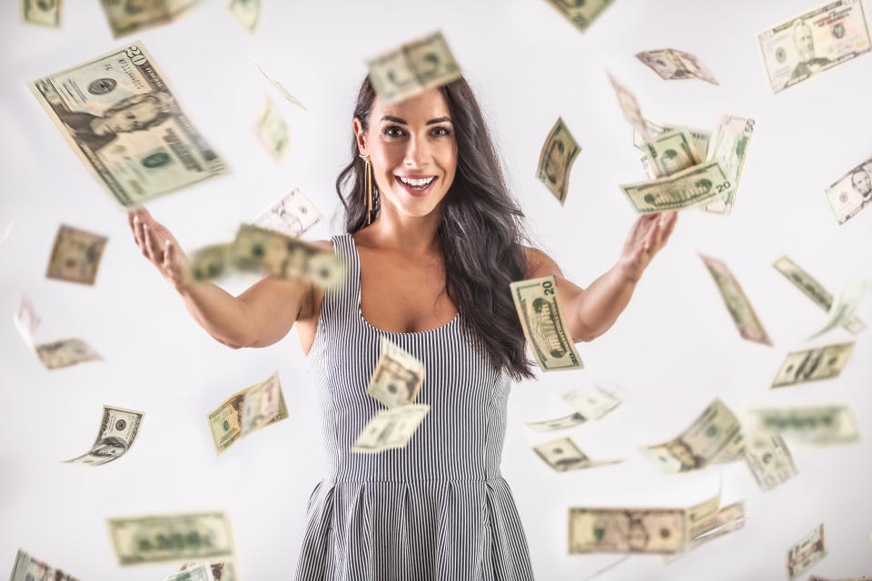 A young woman is throwing around a lot of dollar bills. Lottery winning concept.