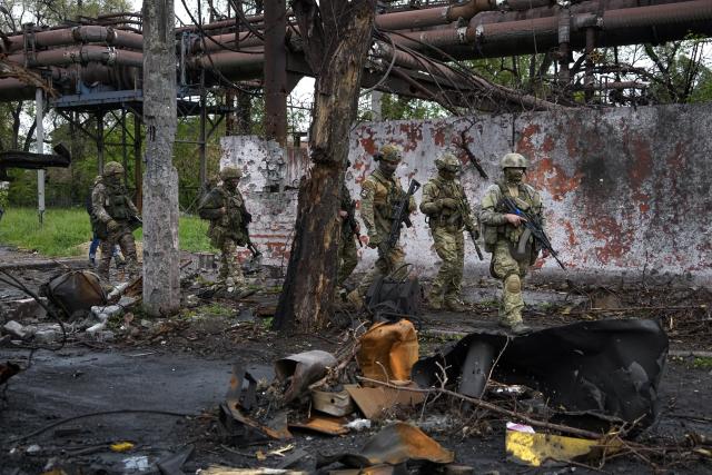 FILE - Russian troops walk in a destroyed part of the Illich Iron &amp; Steel Works Metallurgical Plant in Mariupol, in territory under the government of the Donetsk People's Republic, eastern Ukraine, May 18, 2022. This photo was taken during a trip organized by the Russian Ministry of Defense. Three months after it invaded Ukraine hoping to overtake the country in a blitz, Russia has bogged down in what increasingly looks like a war of attrition with no end in sight. (AP Photo, File)