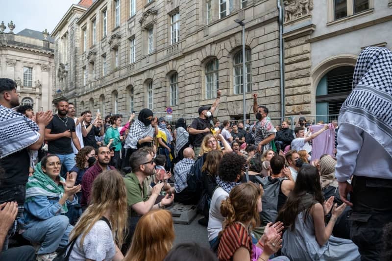 Pro-Palestinian demonstrators sit and stand in front of the Institute of Social Sciences at Humboldt University. Activists have occupied rooms at Berlin's Humboldt University in support of the Palestinians and in protest against Israel. Soeren Stache/dpa