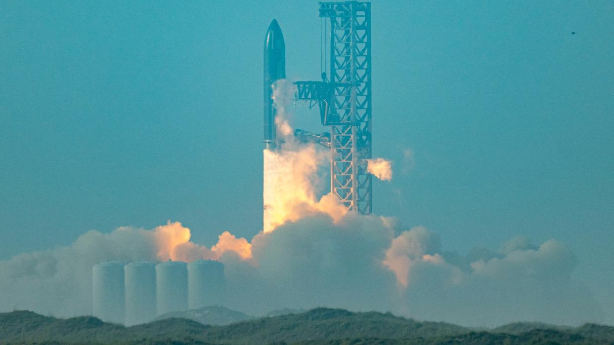  a massive cloud of dust is kicked up by a huge rocket on a launch pad 