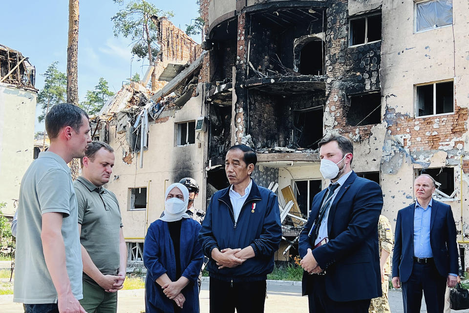 In this photo released by the Press and Media Bureau of the Indonesian Presidential Palace, Indonesian President Joko Widodo, center, and his wife Iriana, third left, talk to residents near an apartment building damaged by shelling, during his visit in the town of Irpin on the outskirts of Kyiv, Ukraine on Wednesday, June 29, 2022. (Laily Rachev, Indonesian Presidential Palace via AP)