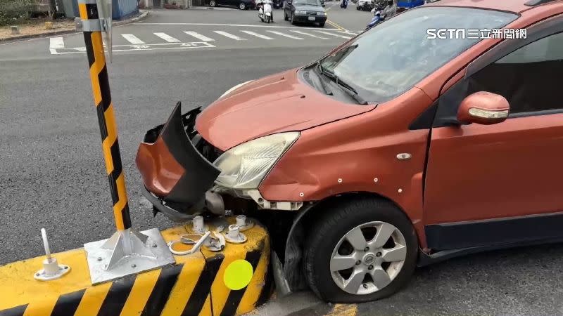 紅色轎車撞上庇護島，前保險桿撞壞。