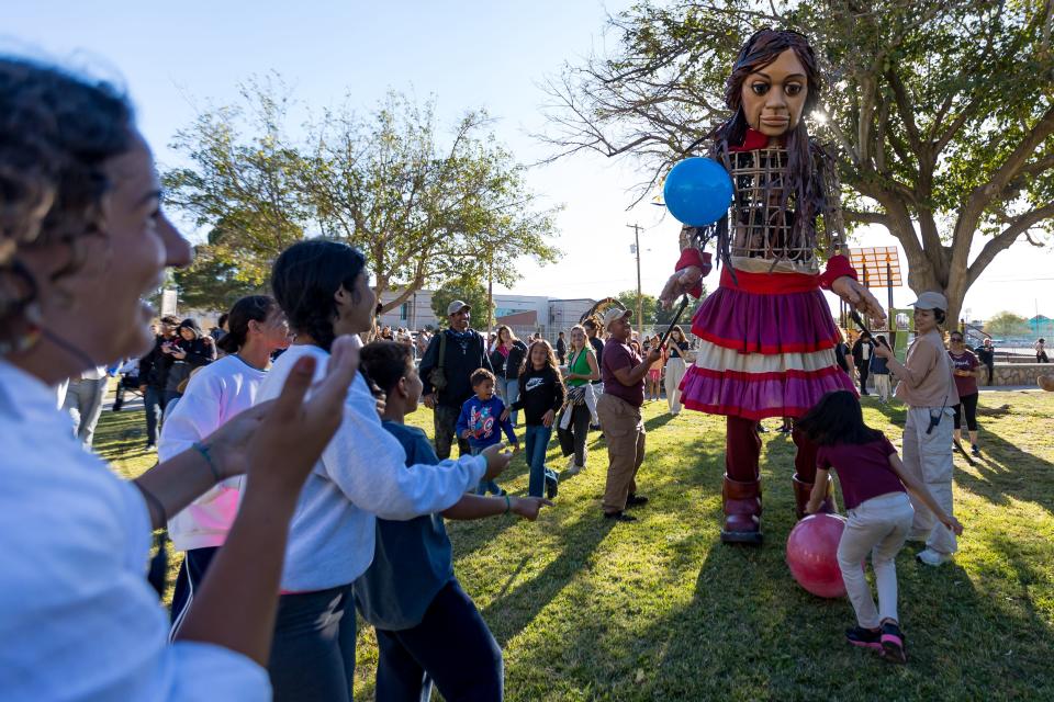 Little Amal, the 12-foot puppet of a ten-year-old Syrian child, plays with the kids at her first stop in El Paso at Armijo Park in Segundo Barrio on Wednesday, Oct. 25, 2023.