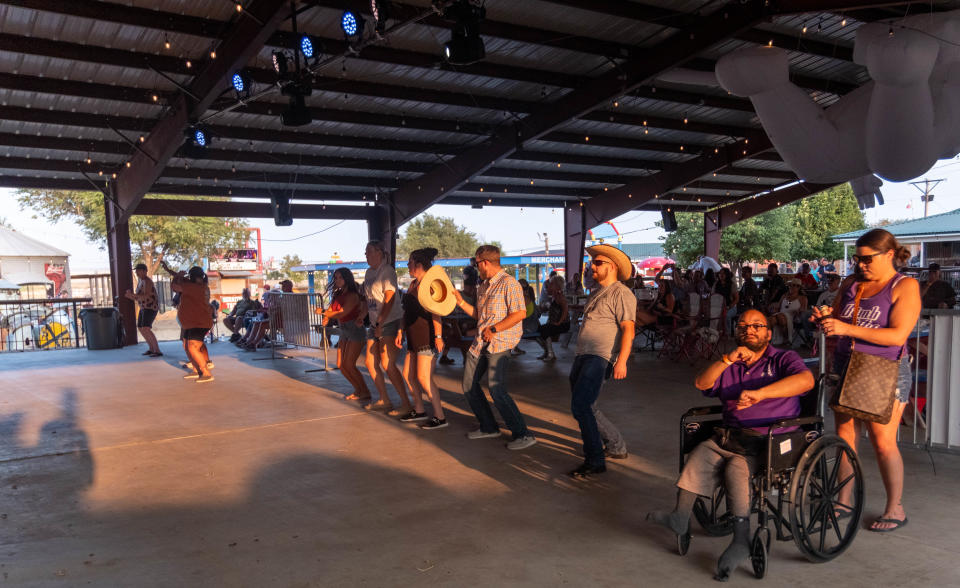 A group shakes their tailfeather to the bands rendition of "Wobble" Saturday evening at the 1st annual Calf Fry Festival at the Starlight Ranch Event Center in Amarillo.
