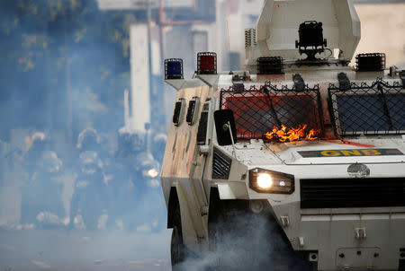 A flame from molotov cocktails thrown at a water cannon by opposition supporters is pictured during a rally against Venezuela's President Nicolas Maduro in Caracas, Venezuela, April 26, 2017. REUTERS/Carlos Garcia Rawlins