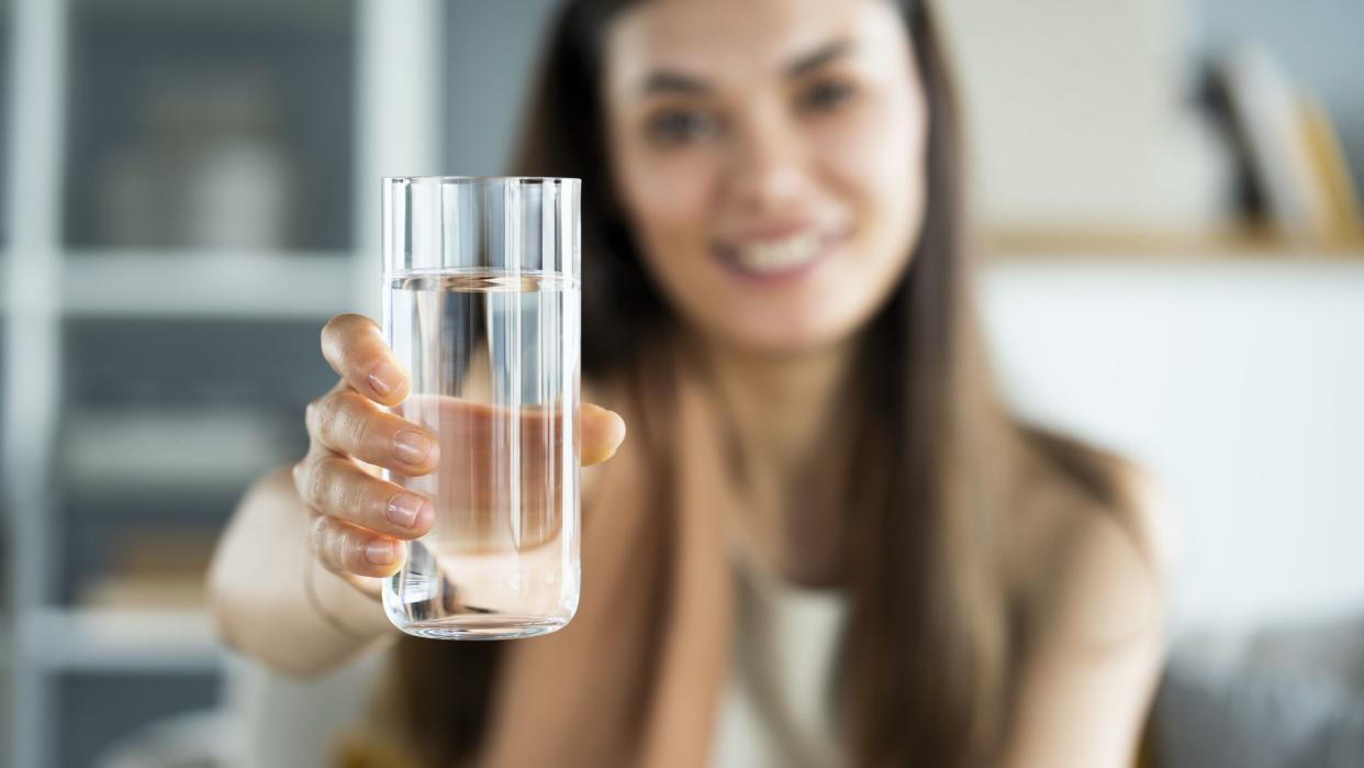 Young woman drinks a glass of water