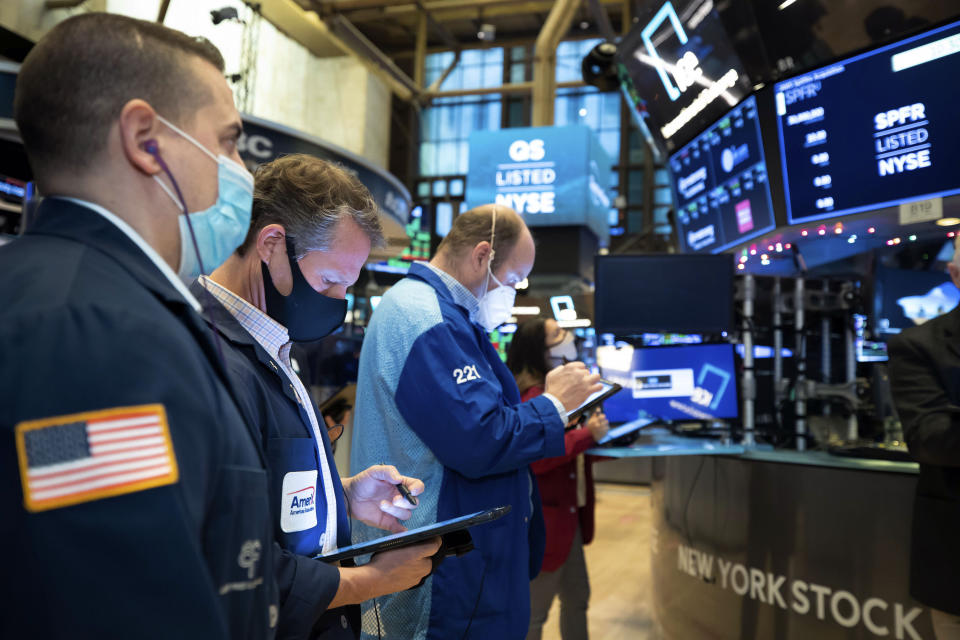 In this photo provided by the New York Stock Exchange, traders work on the floor, Thursday Dec. 3, 2020. U.S. stocks are inching further into record heights Thursday, as Wall Street continues to coast following its rocket ride last month powered by hopes for coming COVID-19 vaccines. (Nicole Pereira/New York Stock Exchange via AP)