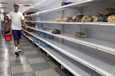 People walk looking for products at a supermarket in Caracas, Venezuela August 18, 2018. REUTERS/Carlos Garcia Rawlins