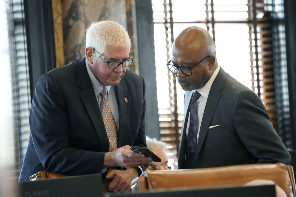 Mississippi State Rep. Robert Johnson, D-Natchez, right, and Mississippi Senate Medicaid Committee Chairman Sen. Kevin Blackwell, R-Southaven, review a document on a cell phone in the Senate Chamber at the state Capitol in Jackson, Miss., Thursday, May 2, 2024. (AP Photo/Rogelio V. Solis)