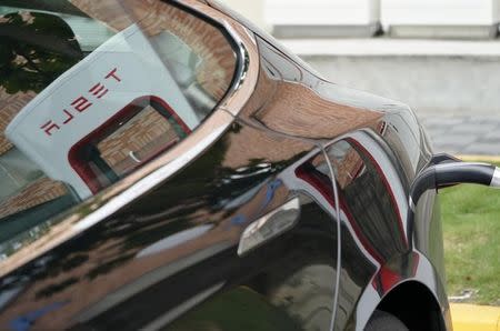 A Tesla Model S electric car is charged by a supercharger at its showroom in Taipei, Taiwan August 11, 2017. REUTERS/Tyrone Siu/Files