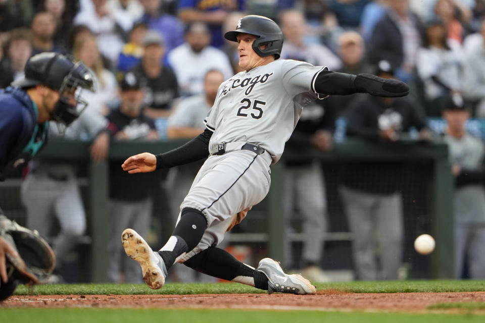 Chicago White Sox's Andrew Vaughn slides in front of the throw to Seattle Mariners catcher Cal Raleigh to score during the seventh inning of a baseball game Monday, June 10, 2024, in Seattle. (AP Photo/Lindsey Wasson)