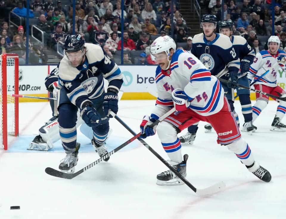 Feb. 25, 2024; Columbus, Ohio, USA; 
Columbus Blue Jackets defenseman Erik Gudbranson (44) and New York Rangers center Vincent Trocheck (16) chase a puck during the second period of an NHL game at Nationwide Arena on Sunday.