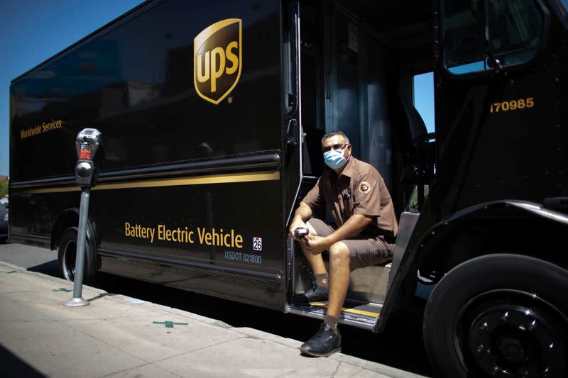 UPS Driver Gilbert Lopez poses with his electric UPS truck, amid the global outbreak of the coronavirus disease (COVID-19), in Los Angeles