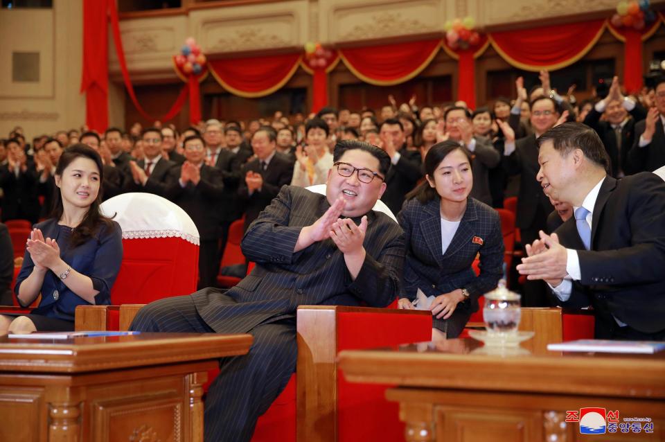 Fotografía facilitada por la agencia norcoreana KCNA que muestra al líder de Corea del Norte, Kim Jong-un (c), y a su mujer, Ri Sol-ju (i), que disfrutan del espectáculo del Destacamento Rojo de Mujeres en Pionyang (Corea del Norte) ayer, 16 de abril de 2018. KCNA. EFE/ Kcna