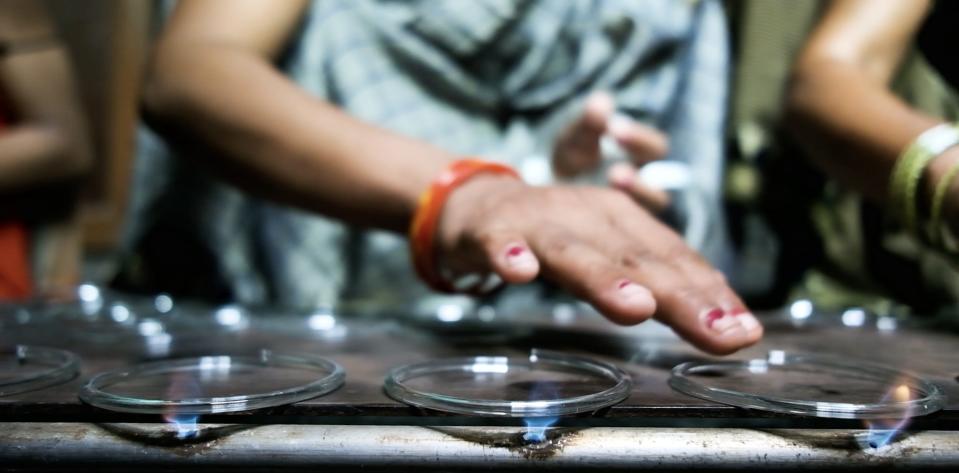 Women use small flames to bind the ends of the bangles