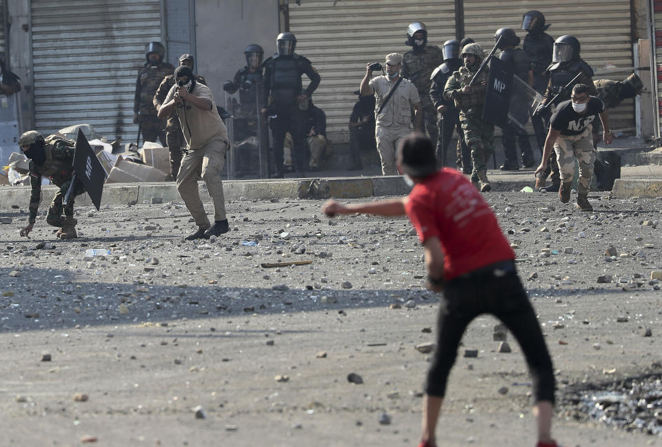 A protester prepares to throw a stone during clashes between Iraqi security forces and anti-government protesters in Baghdad, Iraq, Monday, Nov. 11, 2019. (AP Photo/Hadi Mizban)