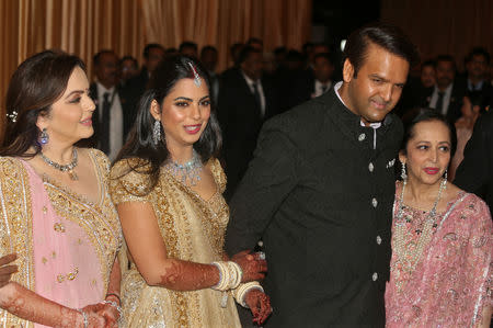 (L-R) Nita Ambani, wife of the Chairman of Reliance Industries Mukesh Ambani, her daughter Isha Ambani, Isha's husband Anand Piramal, heir to a real-estate and pharmaceutical business, and Anand's mother Swati Piramal pose during the wedding reception of Isha and Anand in Mumbai, India, December 14, 2018. REUTERS/Francis Mascarenhas